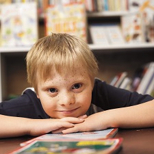 Boy smiling with books in library